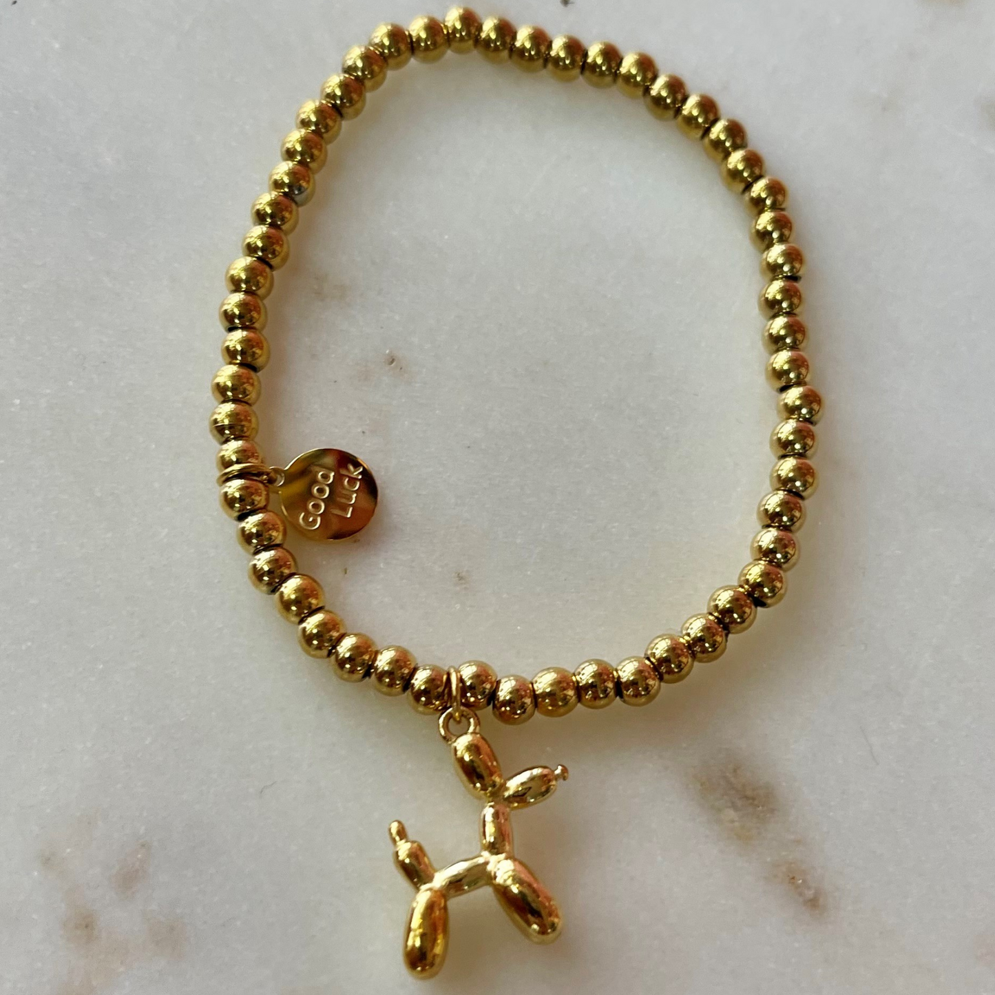 gold band bracelet with Good Luck charm and a gold balloon shaped dog