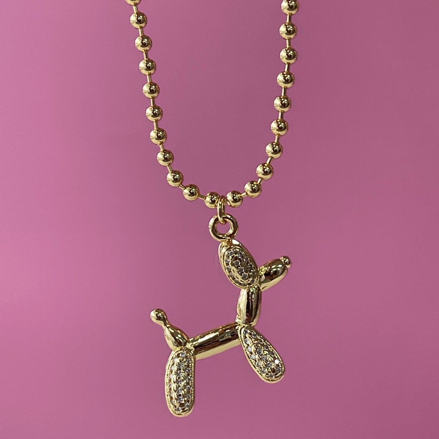 gold tone 16 in adjustable necklace with a balloon shaped dog with red rhinestones