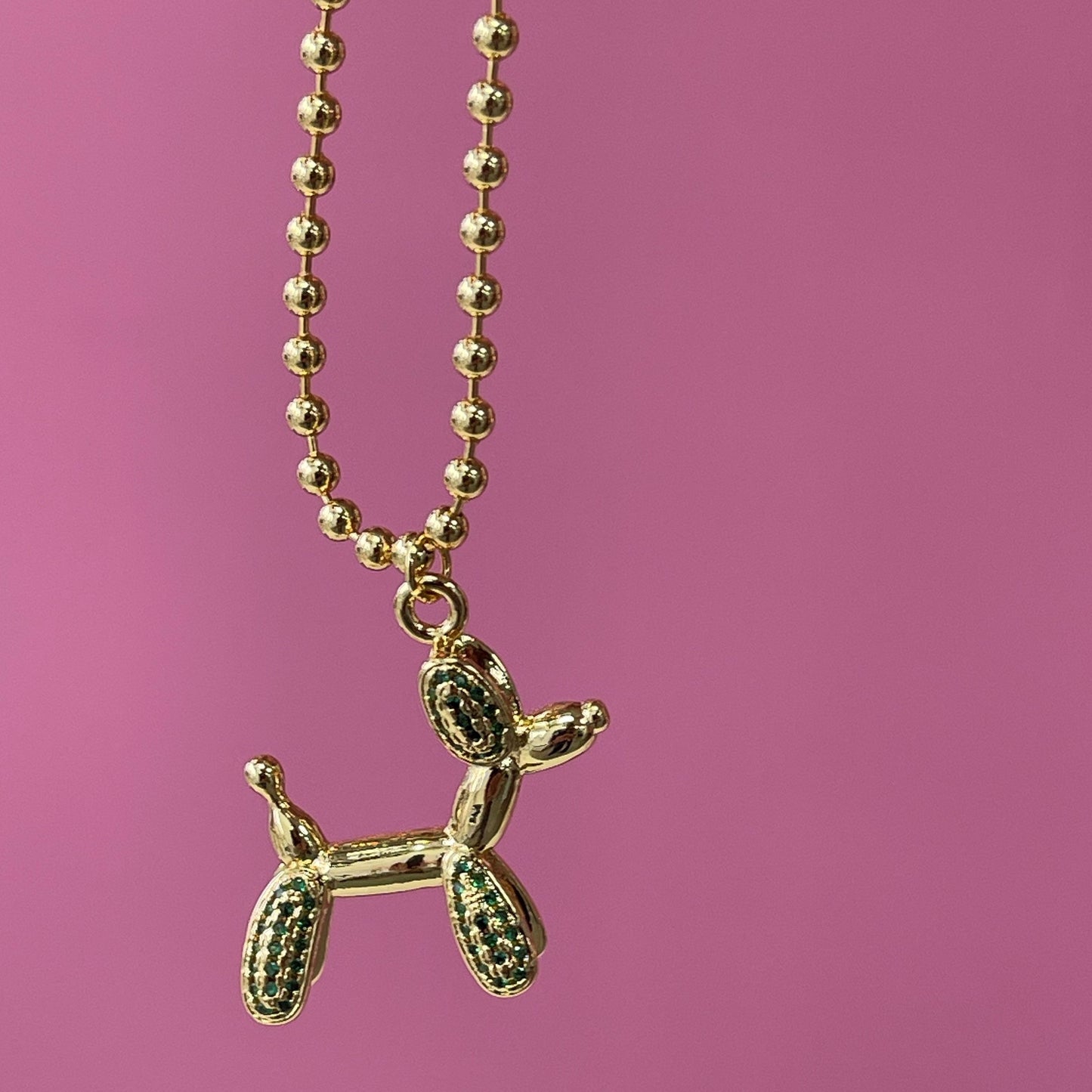 gold tone 16 in adjustable necklace with a balloon shaped dog with red rhinestones